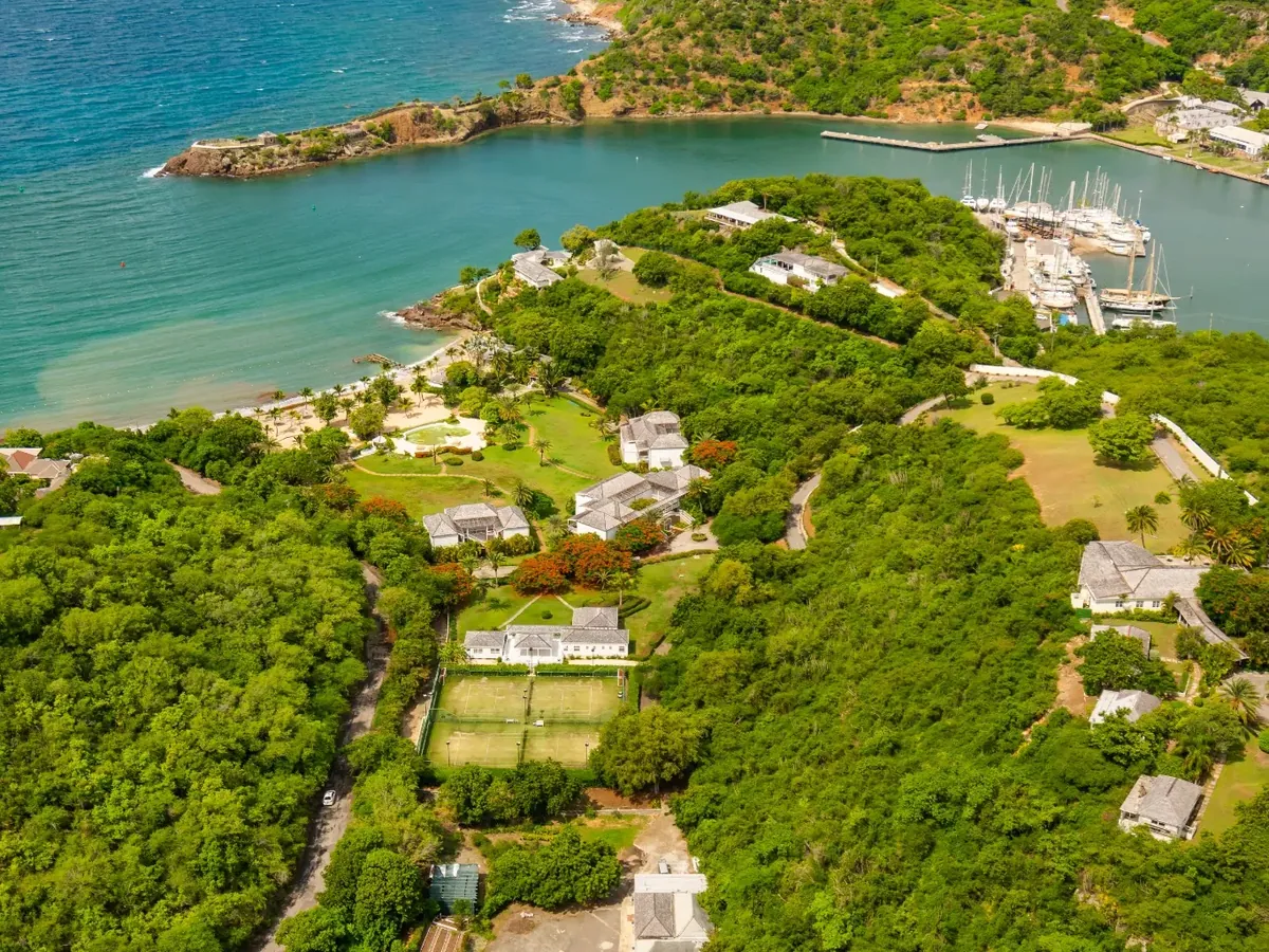 Aerial view of hillside homes above a bay and marina in Antigua