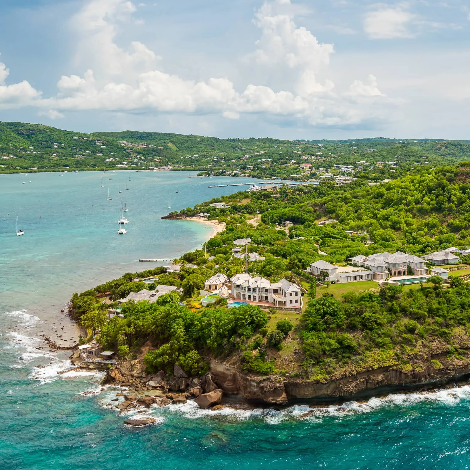 Aerial view of hillside villas above a sheltered bay in Antigua